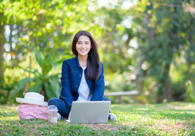 Chica estudiante usando la computadora en el parque