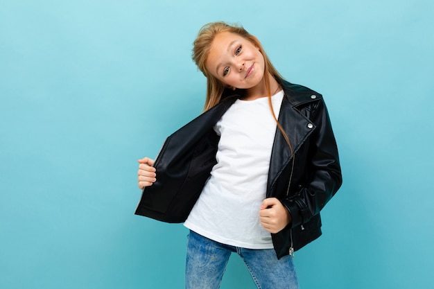 chica europea en un look casual con una chaqueta de cuero y jeans desabrochó su chaqueta en azul claro