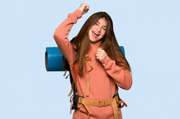 Chica excursionista celebrando una victoria en azul