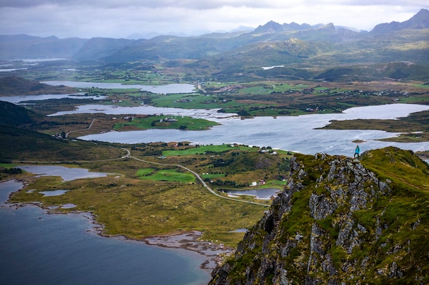 chica excursionista se encuentra en la cima de Offersoykammen disfrutando del panorama de las islas lofoten, Noruega