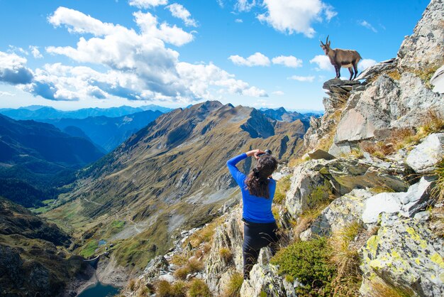 Chica excursionista fotógrafo ibex en las montañas