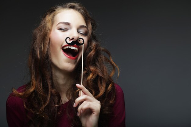 Chica feliz con bigotes falsos Listo para la fiesta