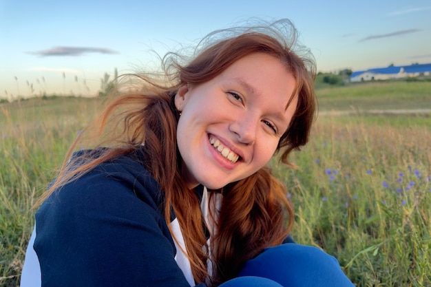 Chica feliz en el campo en verano al amanecer o al atardecer disfrutando de la naturaleza