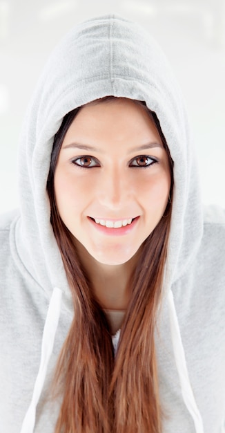 Chica feliz con capucha y sudadera gris.