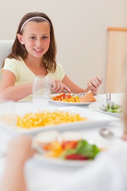 Chica feliz cenando en la mesa