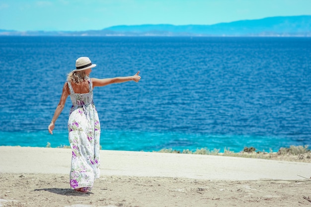 Una chica feliz cerca de la orilla del mar en un viaje de fin de semana por la naturaleza