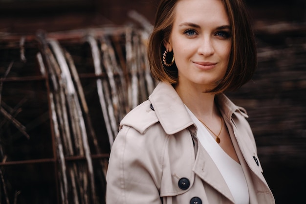 Una chica feliz y elegante con un abrigo gris camina por la ciudad