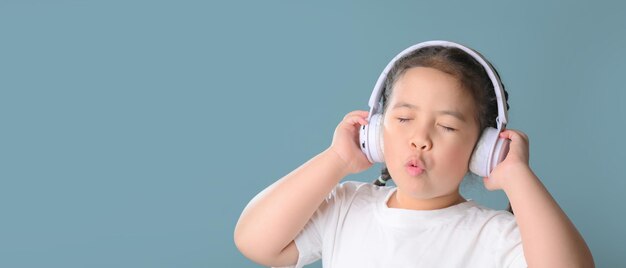 Chica feliz escuchando música en auriculares, tecnología musical y concepto de personas