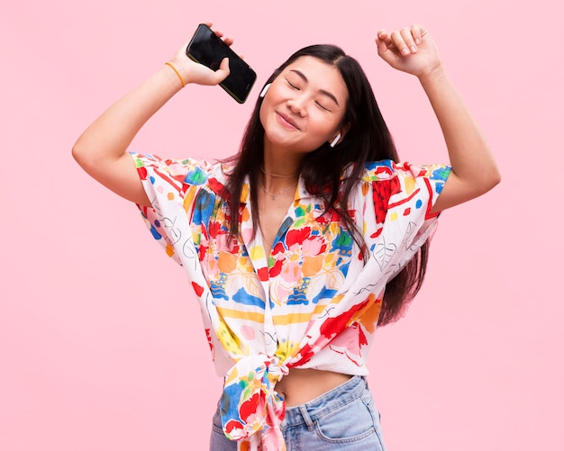 Foto chica feliz escuchando música en smartphone