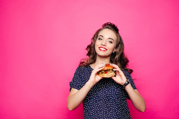 Chica feliz con una hamburguesa.