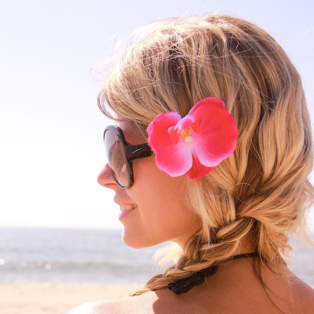 Chica feliz en el hombro del corazón de la playa en verano en la naturaleza