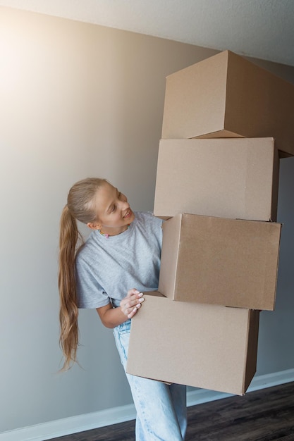 Chica feliz mudándose a una casa nueva con cajas de cartón