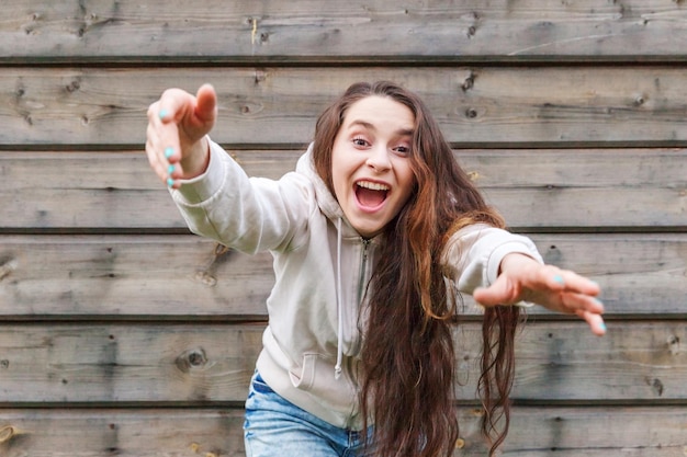 Chica feliz sonriente Retrato de belleza joven feliz positiva riendo mujer morena sobre fondo de pared de madera