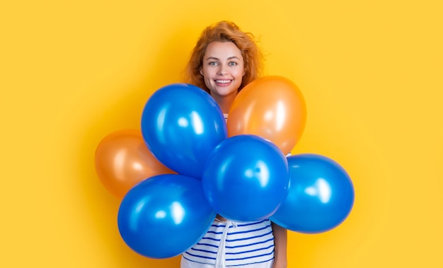 Chica feliz sostener globos de fiesta en estudio chica con globo para fiesta aislado sobre fondo amarillo
