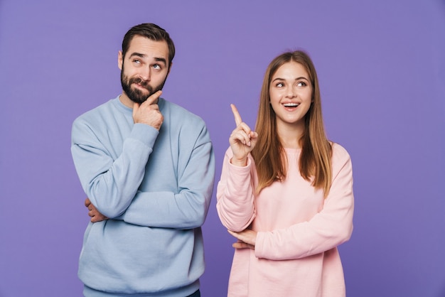 chica feliz tiene una idea cerca de pensar novio aislado sobre pared púrpura.