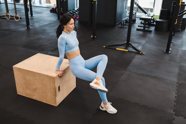 Chica fitness ejercicio en caja de madera para crossfit