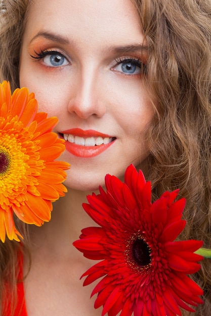 Chica con flor de gerbera en estudio