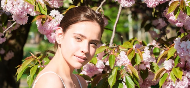 Chica en flores de cerezo sakura Retrato al aire libre de hermosas chicas de moda sensual posando cerca de bl