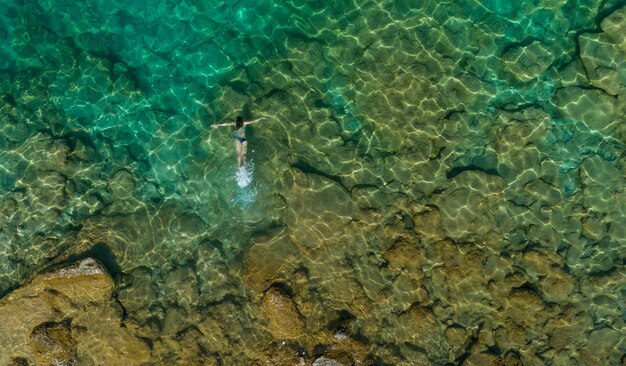 Chica flotando en el agua, vista superior