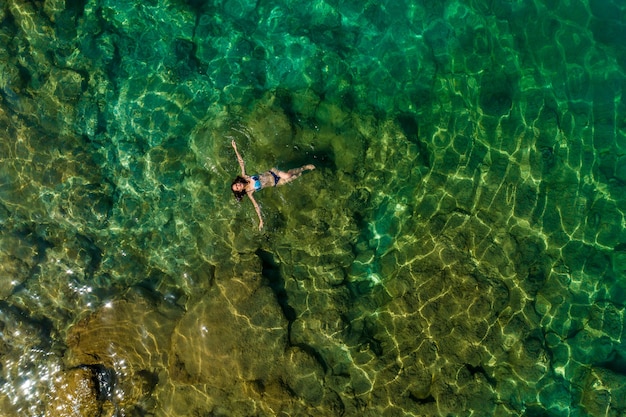 Chica flotando en el agua, vista superior