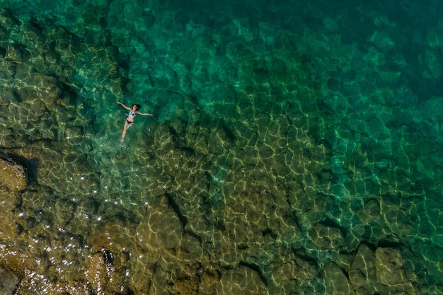 Chica flotando en el agua, vista superior