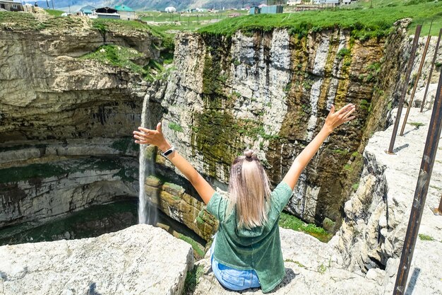 Chica en el fondo de la cascada de Tobot Cascadas de Khunzakh Daguestán Rusia 2021