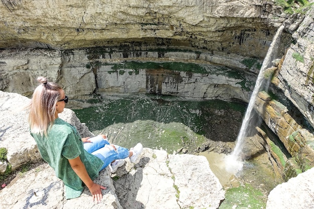 Chica en el fondo de la cascada de Tobot Cascadas de Khunzakh Daguestán Rusia 2021