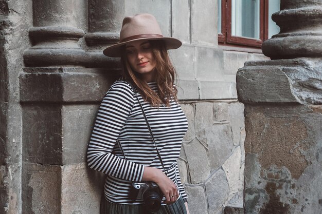 Chica fotógrafa con sombrero con cámara de fotos retro