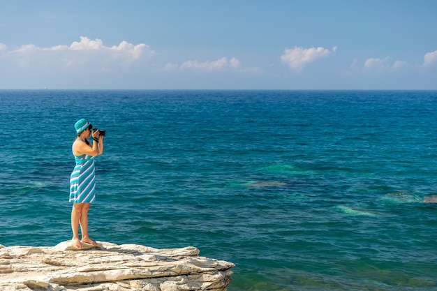 Foto chica fotógrafa toma una foto del mar.
