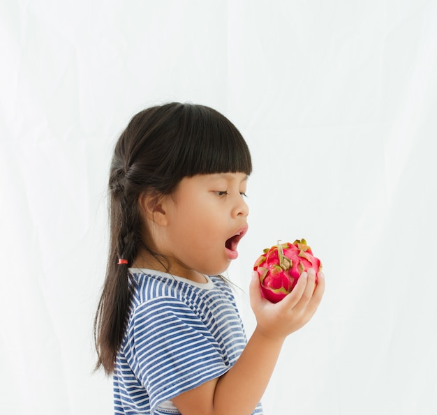 Chica de fruta de dragón en mano sobre fondo blanco