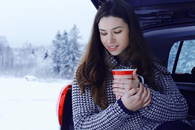 chica fuera de invierno con una taza de bebida caliente