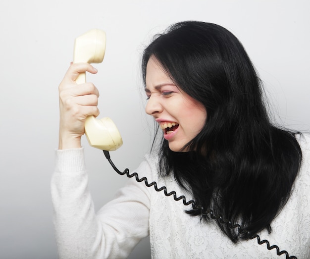 Chica furiosa con teléfono vintage