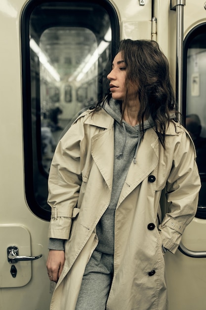 Foto una chica con una gabardina beige viaja en un vagón de metro.