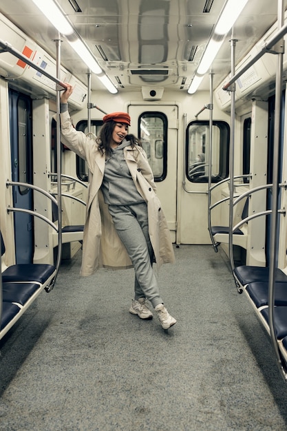 Foto una chica con una gabardina beige viaja en un vagón de metro.