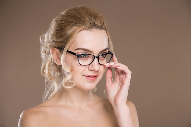 Chica con gafas con la mano cerca de la cara