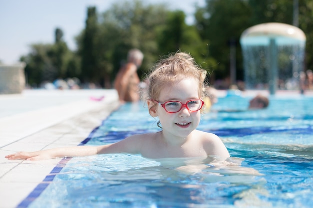 Chica con gafas nadando en la piscina