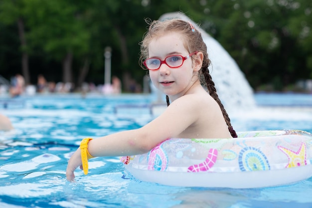 Chica con gafas nadando en la piscina