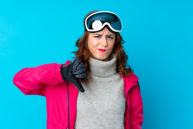 Chica con gafas de nieve sobre pared aislada