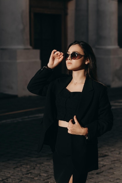 Chica con gafas de sol caminando en la ciudad vieja