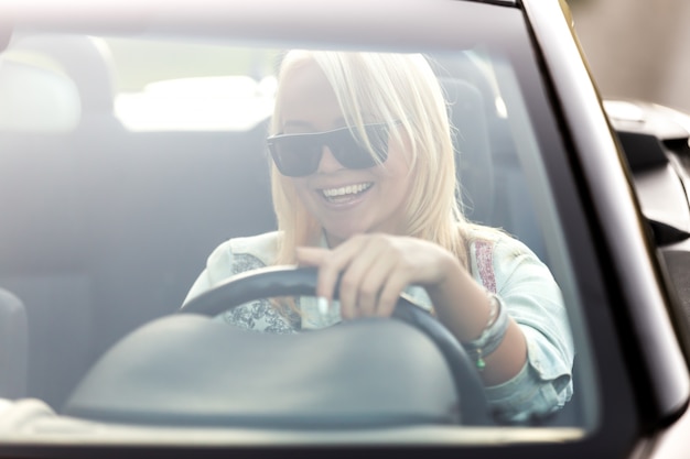 Chica con gafas de sol conduciendo