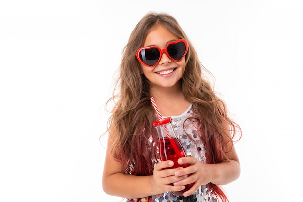 Chica con gafas de sol oscuras con jugo en sus manos