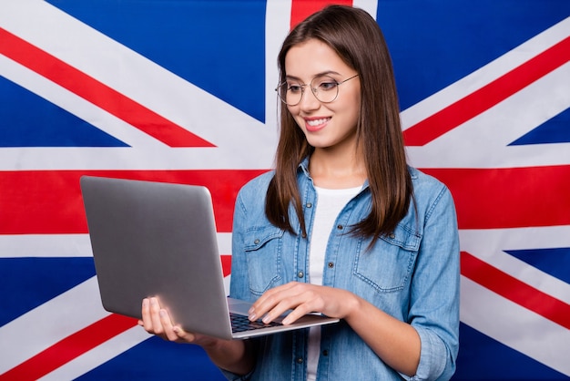 chica con gafas sostiene una computadora portátil