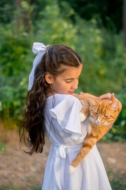 Chica con gato jengibre. Hermoso retrato de niña con gato jengibre en las manos.