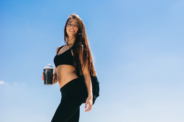 Chica de gimnasio con una coctelera