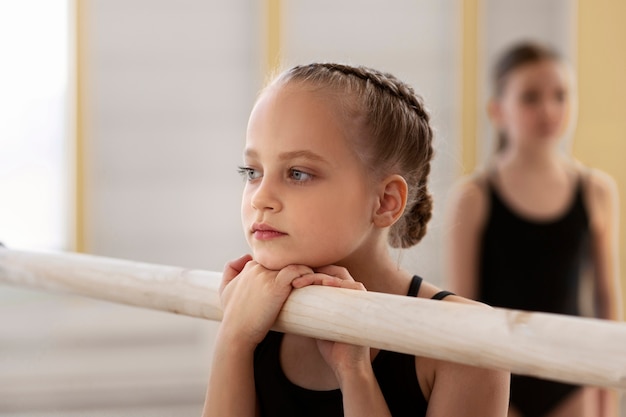 Foto chica en el gimnasio durante una lección de ballet.