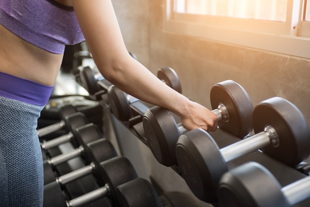 Chica de gimnasio levantando pesas.