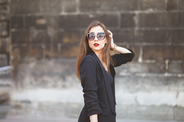 Una chica glamorosa de apariencia modelo posa para una foto en la calle