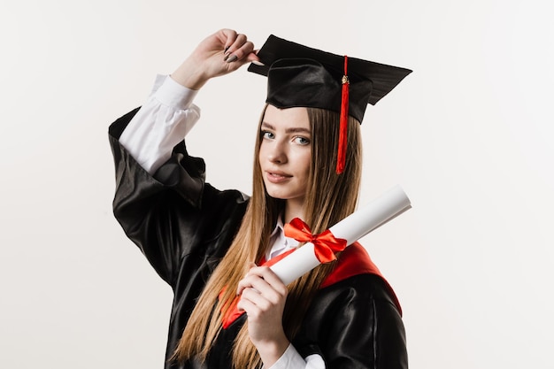 Chica graduada feliz sonriendo y sosteniendo un diploma con honores en sus manos sobre fondo blanco Graduación Chica graduada se graduó de la universidad y obtuvo una maestría