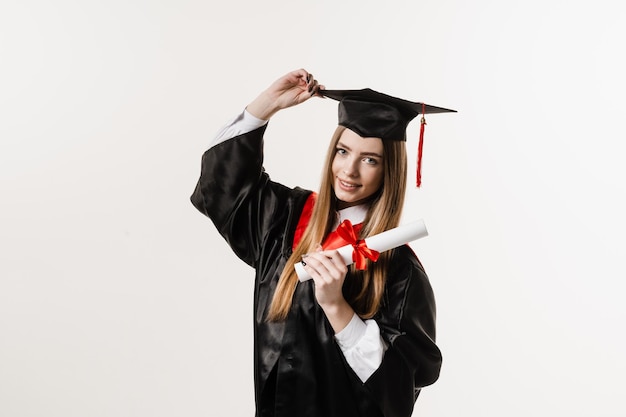 Chica graduada se graduó de la universidad y obtuvo una maestría Graduación Feliz chica graduada sonriendo y sosteniendo un diploma con honores en sus manos sobre fondo blanco