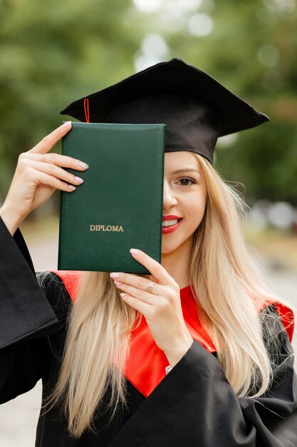 Una chica graduada tiene un diploma en sus manos